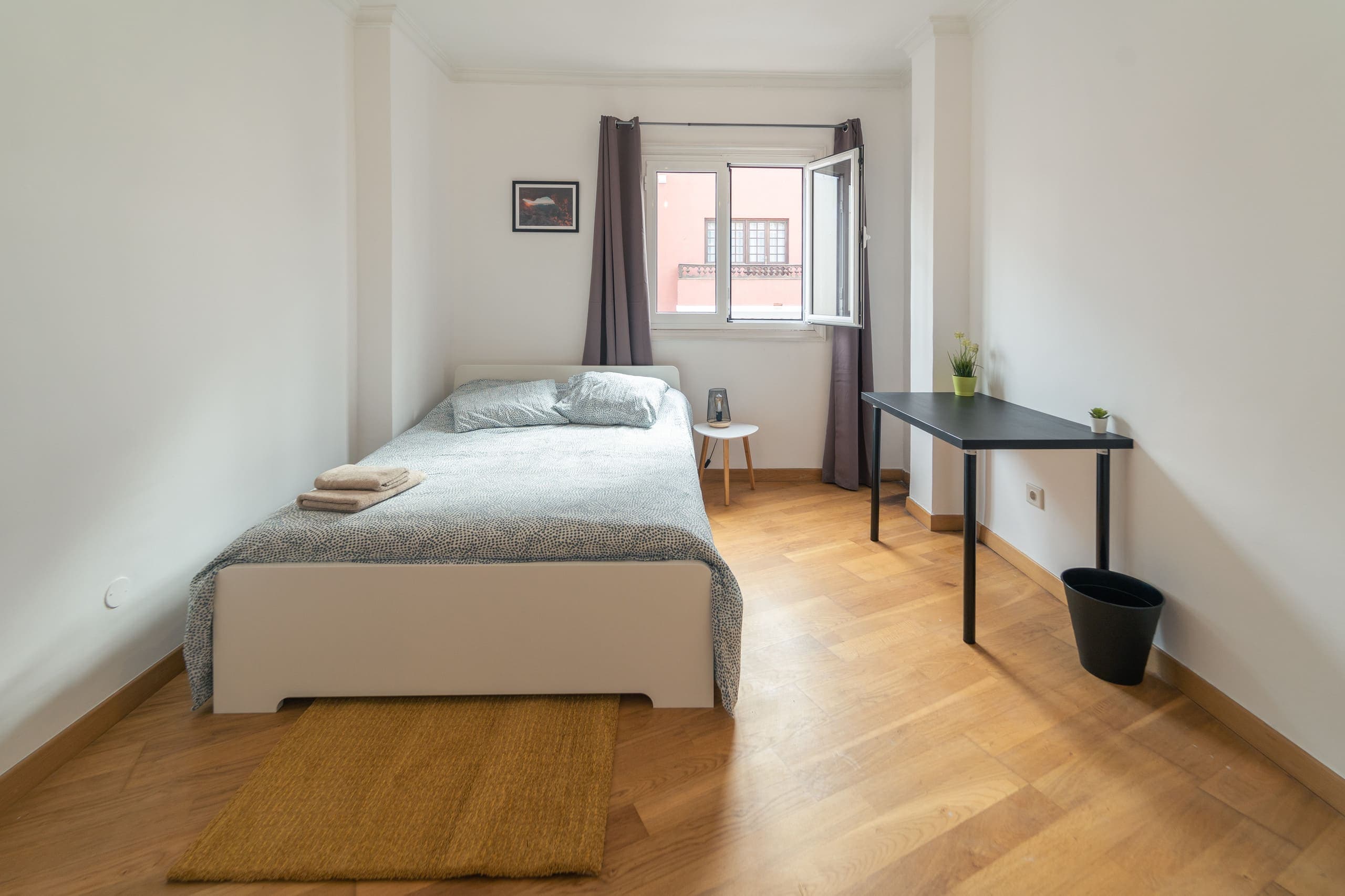 Habitación Americano de House San Telmo: cama doble frente a una ventana con cortinas grises y un escritorio al lado.